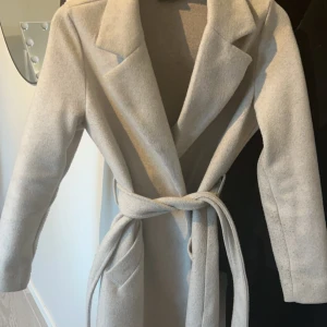 Kappa vero Moda  - Lång Kappa från vero Moda i storlek xs i färgen ”Oatmeal Melange” använd men i fint skick nypris är 649 men säljer för 200💞 skriv privat för bättre bilder 