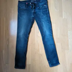 Säljer ett par mörkblå jeans från Replay. Modellen heter Anbass och är deras slim fit modell. Obetydligt använda och således utan slitage på knän eller i grenen. Funkar nog till dig som har 32 i midjan också.