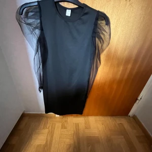  Svart klänning -  Jag säljer denna jättefina svarta klänningen med genomskinliga puffiga armar , Jag säljer den 50 kr skriv om ni är Intresserade