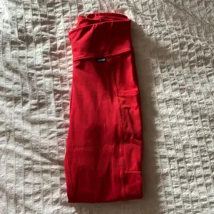 Snygga röda tights med tre fickor. Två större på sidan av låren och en mindre bak i midjan. Finns tillhörande tröja att köpa till. 