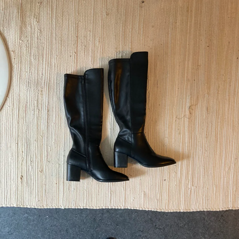 Snygga Höga svarta stövlar i läderimitation, storlek 39. Säljer då jag bara har använt de en gång men sen har de bara fått stå tyvärr. Bara att höra av sig vid frågor🥰. Skor.