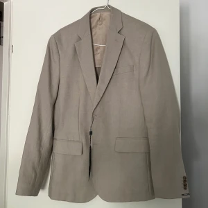 Linnekavaj ifrån J.lindeberg - Säljer nu min helt nya linnekavaj från J.lindeberg Kavajen är skitfräsch nu inför sommaren Beige linnekavaj som kan kombineras med vadsomhelst nu under sommaren Storlek 48  Sitter som S/M  Nypris 4000   Priset är ej hugget i sten