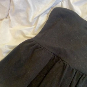 volang topp - svart tubtopp med volang nedtill, använd en gång!