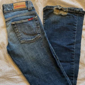 Blå lågmidjade jeans  - Säljer dessa supersnygga lågmidjade vintagejeans då dem tyvärr är för små. Tyvärr trasiga där nere då dem trampats på🫣Dock väldigt lätt att klippa bort eller sy upp. Storlek 34, midjemått 66 cm runt. Benlängd  ca 99 cm om man räknar bort det slitna⭐️