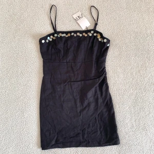 ZARA svart miniklänning med pärlor - Otroligt snygg klänning från ZARA med pärlor. Ny med tags kvar, utan anmärkningar. Dragkedja i ryggen. Material: 50% linne och 50% viskos.
