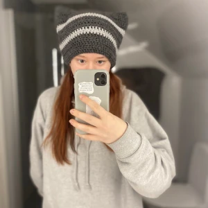 Cat beanie  - Hemmagjord virkad cat beanie, gjord utav mörkt grått och ljus grått garn. 