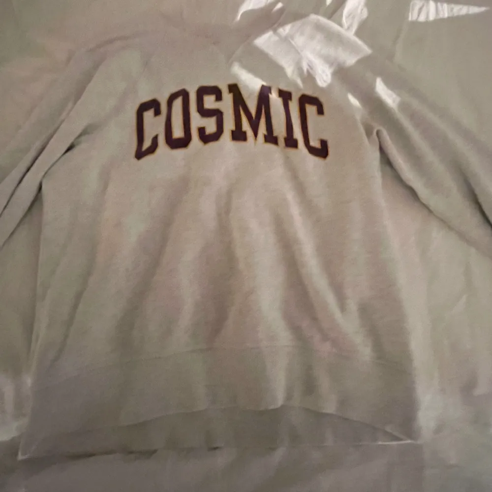 En grå tröja med ”Cosmic” skrivet på framsidan. Köpt från hm i storlek s. . Tröjor & Koftor.