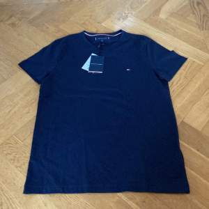 Helt ny Tommy Hilfiger mörkblå T-shirt säljes pga att den var för liten. Inköpt i England nu i januari. Lappen kvar. 