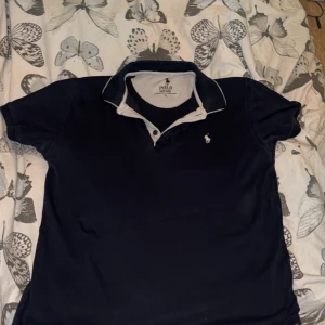 Polo pike! - Snygg polo pike som inte är i bästa skicket, litet hål på vänstra sidan(pm för bild) saknar en av tre knappar ( den längst upp) den är xl men sitter som bäst på L om man vill ha denhär baggya stillen🙏