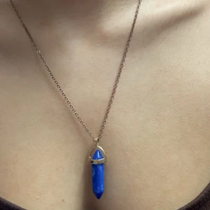 Halsband  - Marinblå kristall halsband. Kristallen är fake och kedjan börjar bli lite rostig. Går att byta ut kedjan eller använda den som den är.