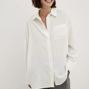 Vit skjorta - Vit skjorta med tunna linjer från NA-KD. Storlek 34 men oversize. Säljes då den tyvärr inte kommer till användning ☺️