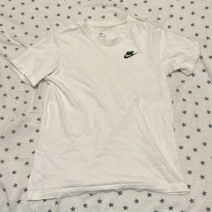 Vit Nike t shirt - Hej säljer min vita Nike t shirt. Den är i perfekt skick och är perfekt nu när de blir varmt i sommar. Passar med allt och är riktigt snygg.