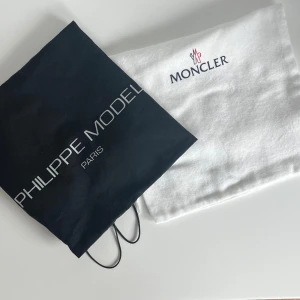 Två påsar från Moncler och Philippe Model - Påsen från Moncler är i sammet. Påsen från Philippe Modell är i bomull. Aldrig använda. Snyggt att hänga i ett rum. 