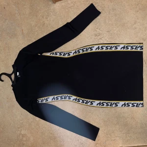 Svart klänning med gul vita markeringar  - En väldigt fin klänning men använder aldrig den längre.