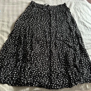 Svart blommig kjol - En svart blommig kjol i storlek L. 