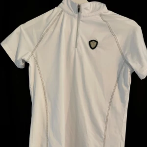 Vit träning/tävlingstopp  - Jättefin tränings/tävlingstopp, använd en gång.   Nypris 400kr Mitt pris 200kr 