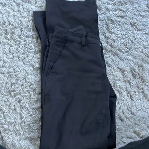 Lowwaist kostymbyxor Vera - super fina svarta kostym byxor, Modell Vera som ej säljs längre. storlek 34. har slits längst ner, Super bra skick förutom liten fläck där vid fickan men är inget man tänker på.