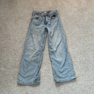 Ljusblåa wide leg jeans - Ljusblåa jeans med breda ben och klassisk femficksdesign. Jeansen har en något sliten look och raka, vida ben. Perfekta för en avslappnad och trendig stil.