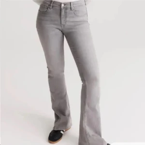 Grå bootcut jeans - Snygga grå jeans med bootcut passform och klassisk femficksdesign. Byxorna har hög midja och stängs med dragkedja och knapp. Perfekta för en trendig vardagslook.