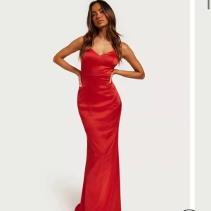 Balklänning röd  - Denna fina balklänning har används en gång och är köpt från Nelly för 1099kr. Den har en mörk röd färg. (ops den är sydd 3/4cm kortare än storleken som står på Nellys hemsida, då den va lite för lång på mig.)