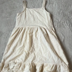 Ljus gul sommarklänning med volang - Söt vit klänning med smala axelband och volang nertill. Köpt utomlands. Storlek 11-12, vilket blir ungefär xs.💞