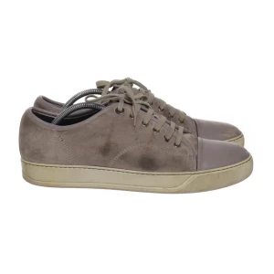 Gråa Lanvin skor - Snygga beige sneakers med ovandel i mocka och tåparti i slätare material. Skorna har snörning och en platt, ljus sula. Perfekta för en avslappnad och stilren look. Sulan har tappat färg samt mockan är lite förstörd på sidan annars finns inget fel och lätt att färga tillbaks färgen 