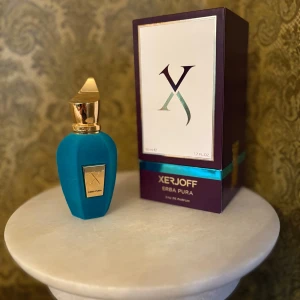 Xerjoff Erba Pura Eau de Parfum - Lyxig parfym från Xerjoff i en elegant turkos flaska med gulddetaljer och matchande ask. Doften Erba Pura är känd för sina fruktiga och fräscha noter, perfekt för dig som vill sticka ut med en exklusiv signaturdoft. NÄSTAN HELT NY