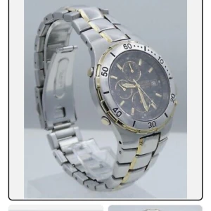 Silverfärgad kronografklocka med gulddetaljer - Stilren herrklocka från Citizen med silverfärgad länkarmband och subtila gulddetaljer. Urtavlan är svart med flera små urtavlor och datumvisning. Klockan har en sportig design med markerad bezel och robust känsla.