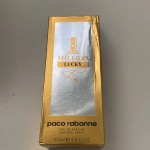 1 Million Lucky Eau de Parfum från Paco Rabanne - 1 Million Lucky från Paco Rabanne är en eau de parfum med en lyxig design i silver och guld. Flaskan har en metallisk finish och rektangulär form, med detaljer i guld och genomskinlig sida som visar den gyllene vätskan. Volymen är 100 ml. Varan produceras inte längre 