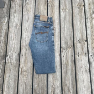 Ijusblåa nudie jeans - Nudie jeans med två slitningar vid era knän. Jätte snygga jeans som passar till vilken outfit som helst! Lappen är lite urtvättad men det syns knappast.Modellen är skinny sam. Nypris är ungefär 1600kr!