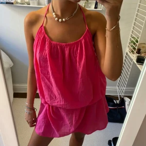 Rosa sommarklänning  - Säljer en superfin rosa klänning med tunna axelband och lös passform. Klänningen har öppen rygg och är tillverkad i ett lätt, luftigt material – perfekt för varma dagar & stranden. Skärp medföljer ej. 