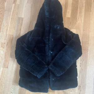 Pälsjacka  - Svart pälsjacka med luva, i ett super skönt Material🖤 fint skick! Storlek 146-152 men skulle kunna passa xxs