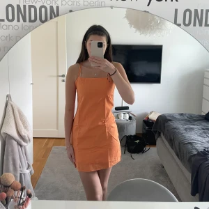 Orange klänning - Orange klänning från H&M i strl 34. Fick begagnad men jag har aldrig använt. Justerbara band i bak samt dragkedja i sidan.