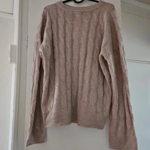 Beige stickad tröja med kabelmönster - Helt ny med prislapp en beige stickad tröja med klassiskt kabelstickat mönster. 