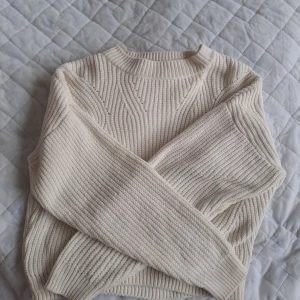 Vit/Beige stickad tröja från H&M - Mysig beige stickad tröja från H&M med ribbad struktur och rund halsringning. 🤍Tröjan har lång ärm och är perfekt för kyligare dagar. Enkel och stilren design som passar till det mesta. Ställ gärna frågar om ni undrar något!
