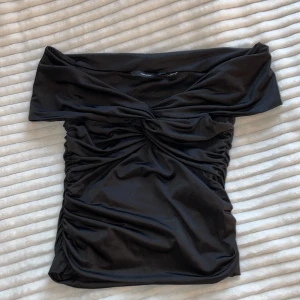 Svart offshoulder tubtopp med drapering - Säljer en tröja från Vera Moda, den är aldrig använd. Storlek xs