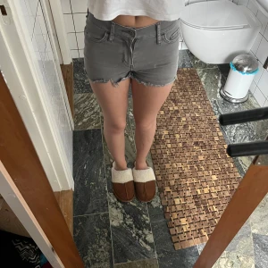 Grå jeansshorts från Hollister - Snygga grå jeansshorts från Hollister. Det är korta och har slitningar längst ner, modellen är lågmidjad och perfekt nu under sommaren.