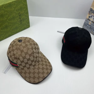 Gucci keps med GG-mönster och ränder - Snygg keps från Gucci med klassiskt GG-monogram över hela kepsen. Finns i både beige och svart med gröna och röda ränder på sidan. Justerbar baktill och tillverkad i bomullscanvas. Perfekt accessoar för en trendig streetstyle.