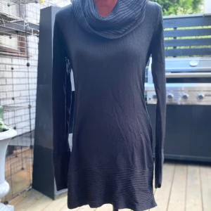 Svart stickad polotröja med ribbade detaljer - Svart stickad tröja med lång ärm och en rullkrage. Tröjan har en ribbad design vid kragen, ärmsluten och nederkanten. Längd: 90 cm ﻿Bystvidd: 55 cm ﻿Uppskattad storlek S  Inga bilder när den sitter på mig! Katter finns i hemmet!