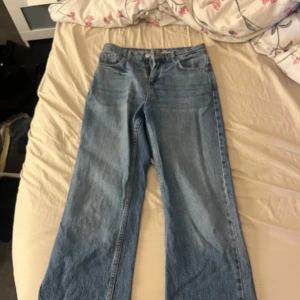 Blå jeans LASSIE 34 wide fit - Säljer ett par klassiska blå jeans från LASSIE i storlek 34. Jeansen har en rak och lite vidare passform med fem fickor och normal midja. Tillverkade i slitstark denim med snygg ljusblå tvätt. Perfekta för en avslappnad och trendig look.