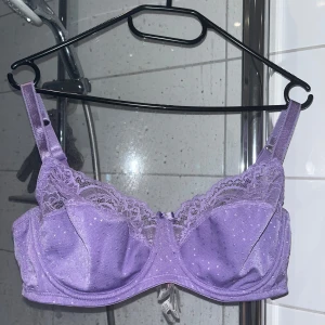 Lila spets-bh från Hunkemöller 85D - Superfin lila bh från Hunkemöller med glittriga prickar, spetsdetaljer upptill och en söt liten rosett med strass i mitten. 
