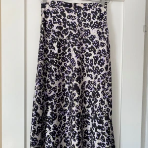 Leopardmönstrad långkjol från Monki - Snygg långkjol från Monki med mönster i svart, lila och beige. I storlek 34. Använda ca 1-w gånger pga för liten. 