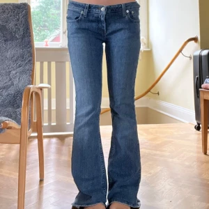 Blå bootcut jeans från Japan  - Snygga blå jeans från en Thrift affär i Japan med bootcut passform och klassisk femficksdesign. Jeansen har dekorativa bakfickor med lock och knappdetalj, samt slitningar för en cool look. Tillverkade i mjukt denim med skön stretch. Säljer dem eftersom de är lite för långa för mig,
