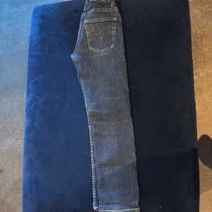 Levi's 510 Skinny jeans blå - Säljer ett par klassiska Levi's 510 Skinny jeans i mörkblå denim. Modellen är tight och har fem fickor, snygga kontrastsömmar och Levi's ikoniska röda etikett på bakfickan. Perfekta för dig som gillar en smal passform och stilren look.