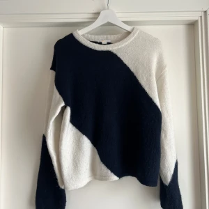 Blåvit stickad tröja Gina Tricot - Gina tricot Young 170. Snygg stickad tröja från Gina Tricot i marinblå och vitt med coolt snedblockigt mönster. Tröjan har rund halsringning och långa ärmar. Materialmix med akryl, polyester, ull och alpacka gör den både mjuk och varm. Perfekt för dig som gillar en trendig och bekväm stil.