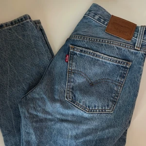 Levi's blå straight jeans Middy 27 - Klassiska blå jeans från Levi's i modellen Middy Straight. Jeansen har raka ben, medelhög midja och är gjorda i slitstarkt denim med snygga kontrastsömmar. Perfekta för dig som gillar en tidlös look. 💕💕