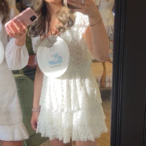 Vit spetsklänning med volanger från Nelly - Supersnygg spettsklänning från nelly! Endast använd på skolavslutning så den är som ny💘 Säljer den endast då jag inte brukar ha klänning!🥰Det är min kompis som har klänningen på bilden🤞🏼