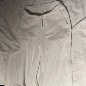 Vita linnebyxor från Grunt - Säljer ett par vita linnebyxor från Grunt i storlek M. Byxorna har resår i midjan med dragsko och sidofickor. Perfekta för varma dagar och en avslappnad stil.