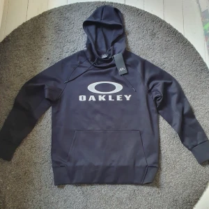 Oakley hoodie - Tjena, säljer min Oakley träningshoodie då den aldrig använts, taggar är kvar. Nypris ligger på runt 800kr. Storlek S men passar mig bra som har M i allt annat. Hör av er vid frågor!