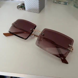 Bruna solglasögon  - Bruna, rektangulära solglasögon som knappt använts. 🤎 Glasen ser lite lila ut på bild men de är mer bruna i verkligheten! Köp gärna bundle och få rabatt!